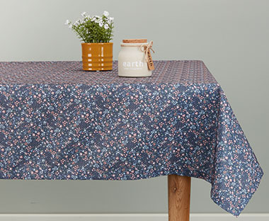 Blå duk med blomstermønster på et bord