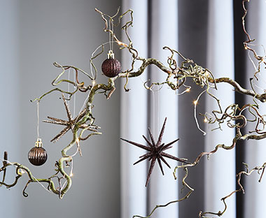 Gren dekorert med julekuler i bruntoner og stjerne pynt