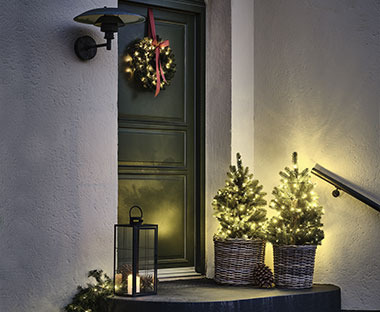 En julepyntet tram med kunstig tre, girlander og julekrans på døren