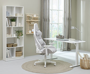 Hvit reol, gamingbord og gamingstol på et hjemmekontor