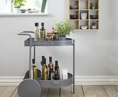 Et grått trillebord brukt som ekstra kjøkkenoppbevaring