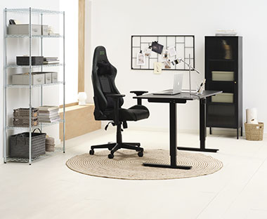 Sort gamingstol og sort skrivebord med hev og senk funksjon