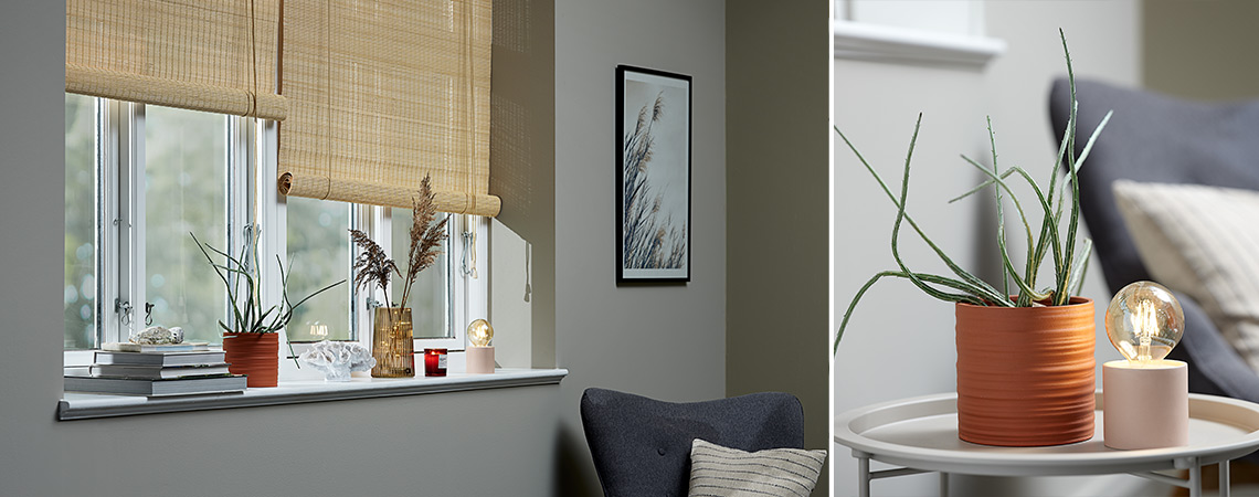 Dekor i vinduskrm bestående av en potteplante, en pyntegjenstand, en vase, et duftlys og en batterilampe