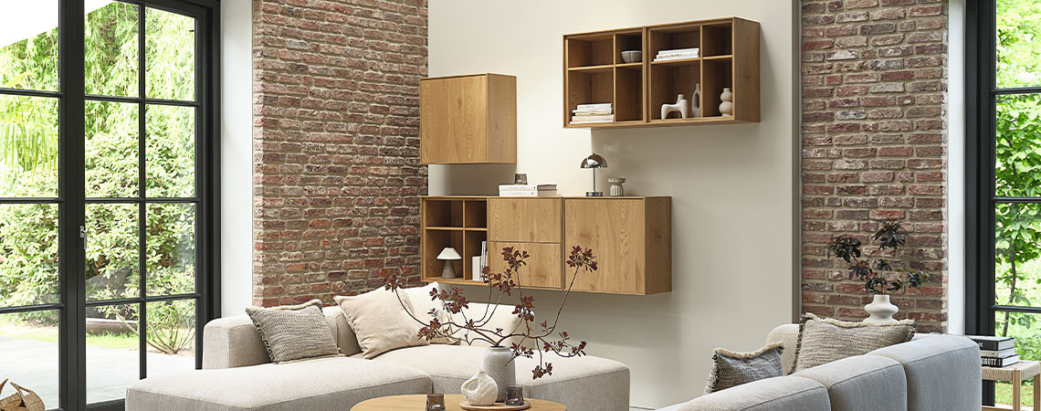 Oppbevaringsmøbler bestående av flere hylleseksjoner montert på en vegg i en stue