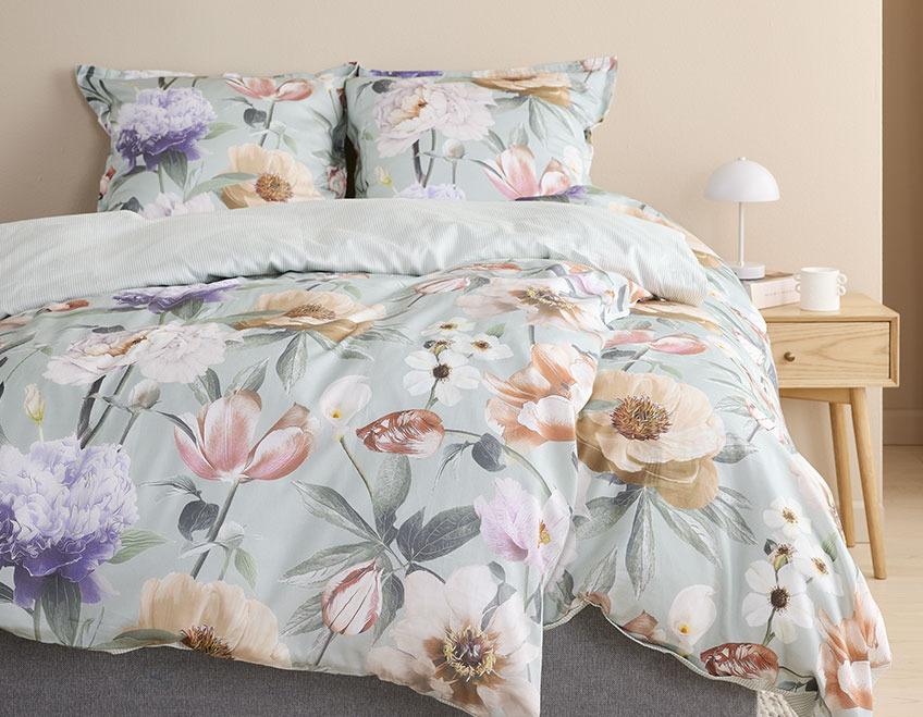 Blomstret sengetøy i et lyst soverom 