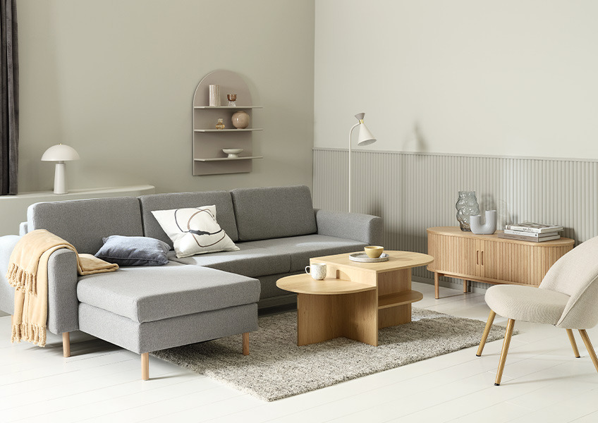 En stue innredet med sofabord, sofa, lenestol og TV-bord