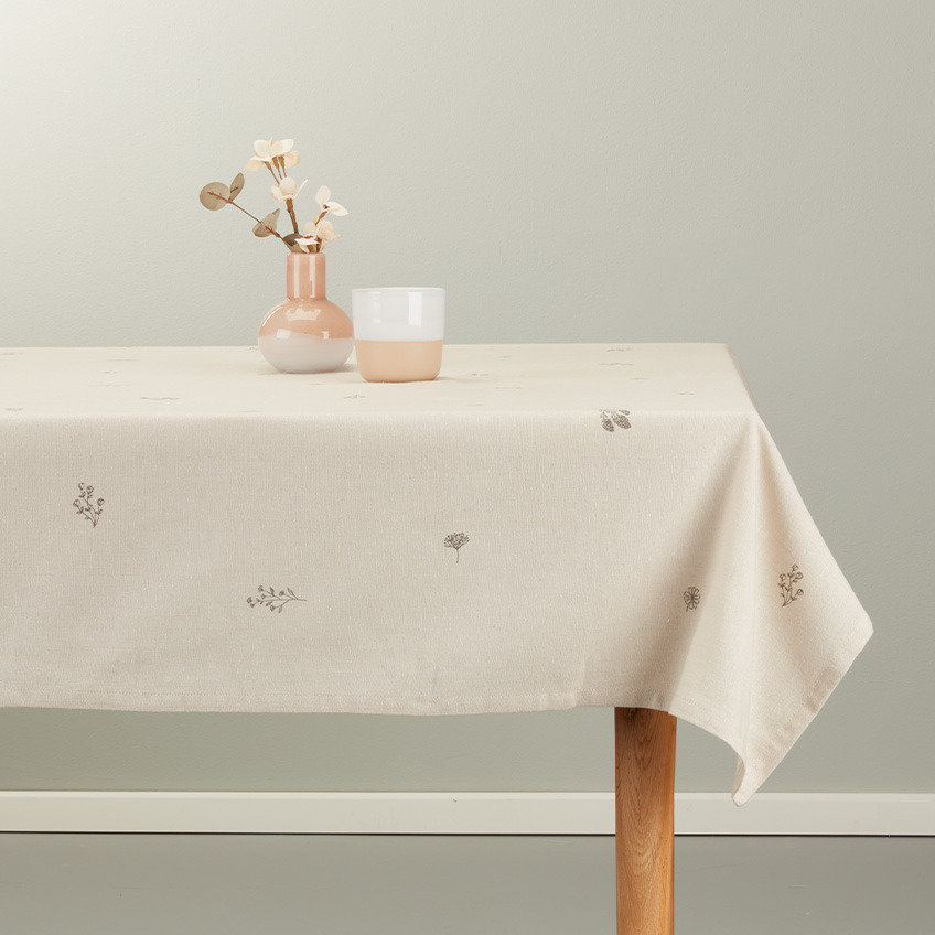Duk på spisebordet i varm beige farge med hvit og ferskenrosa krus og vase 