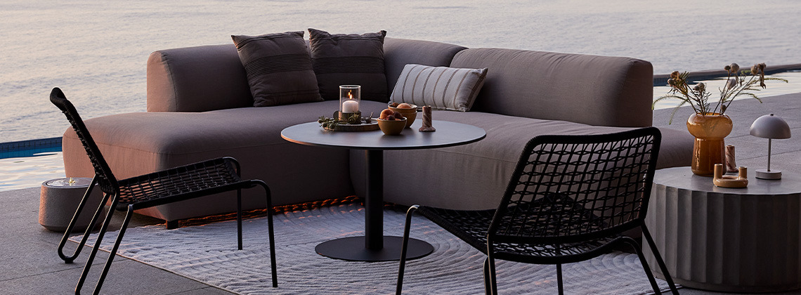 All-værs hurtigtørkende loungesofa og loungestoler på terrassen ved solnedgang