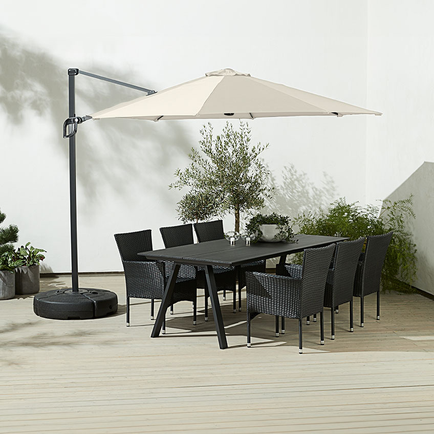 Stor, firkantet offwhite hengende parasoll over utendørs spisebord med hagestoler