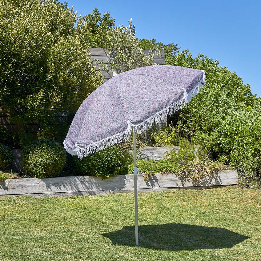 Liten grå parasoll i hagen med vippefunksjon og justerbar høyde 
