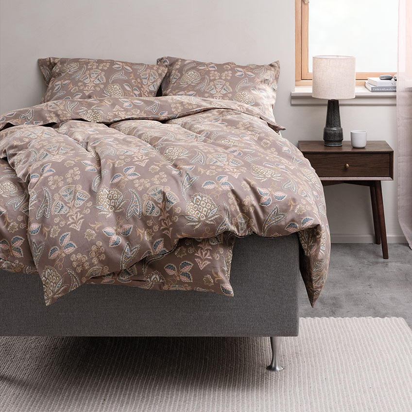 Sengetøy i bomull med Paisley design på en seng i et soverom