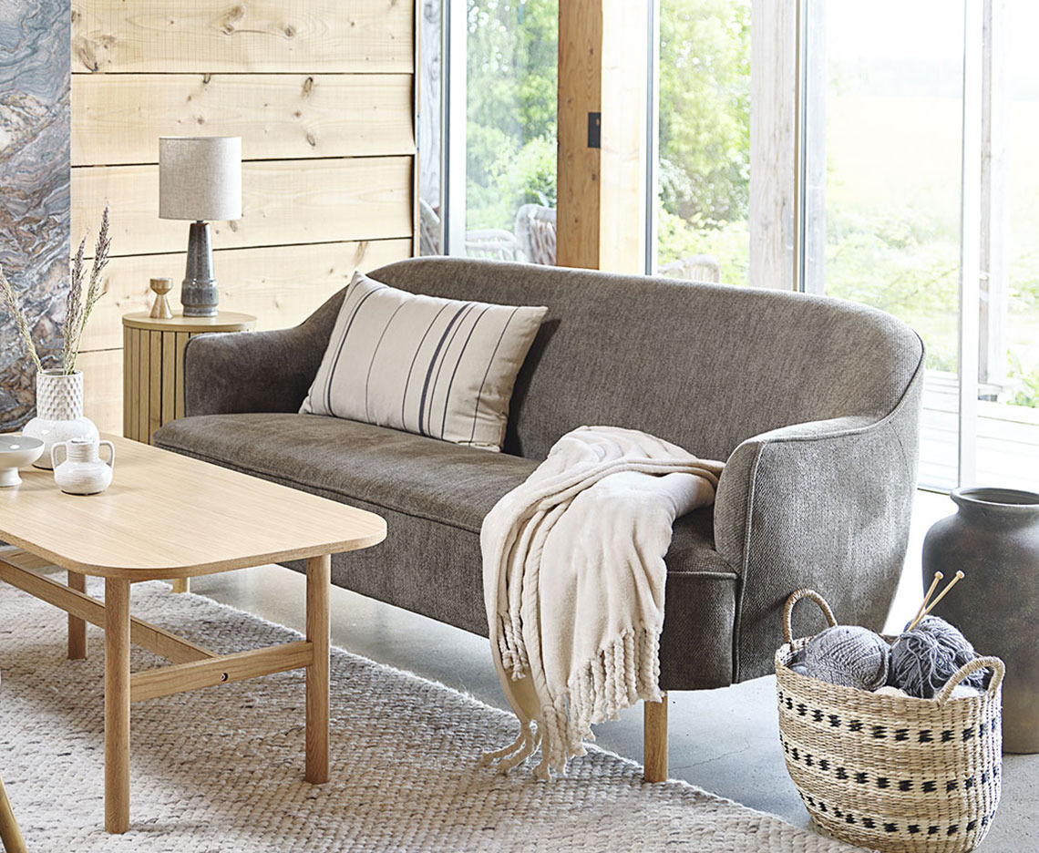 : Grønn 2,5-seters sofa arrangert med sofabord og annen innredning.