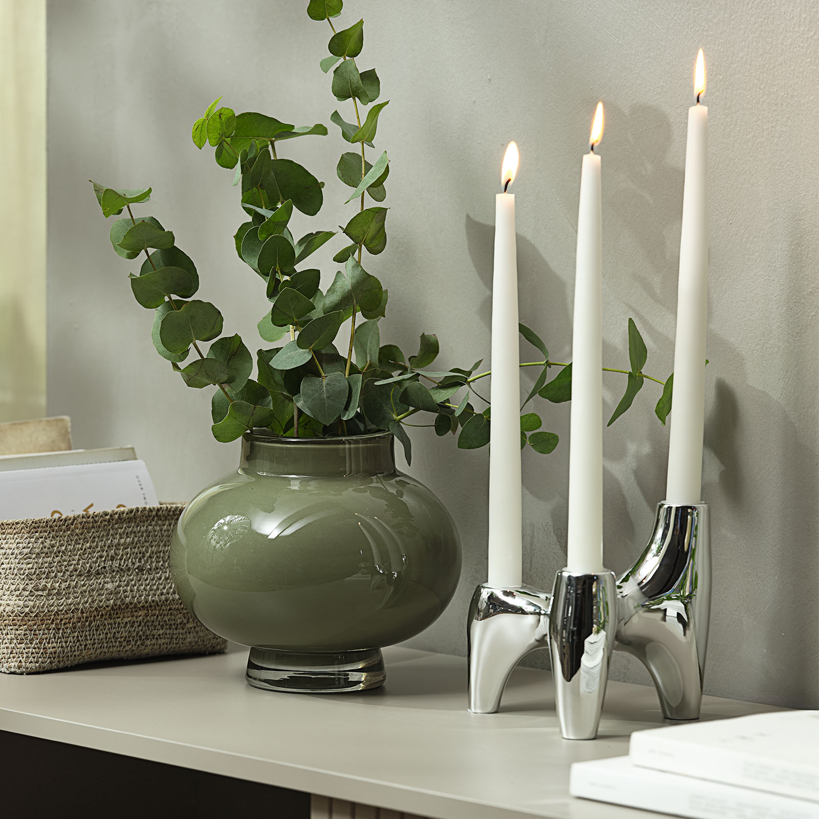 VIGNIR lysestake med kromfinish Kromlysestake med tre lys ved siden av en grønn glassvase med kunstig eukalyptus