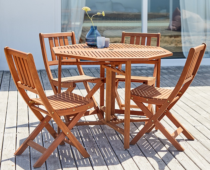 Hagesett i tre med bord og 4 stoler på en terrasse