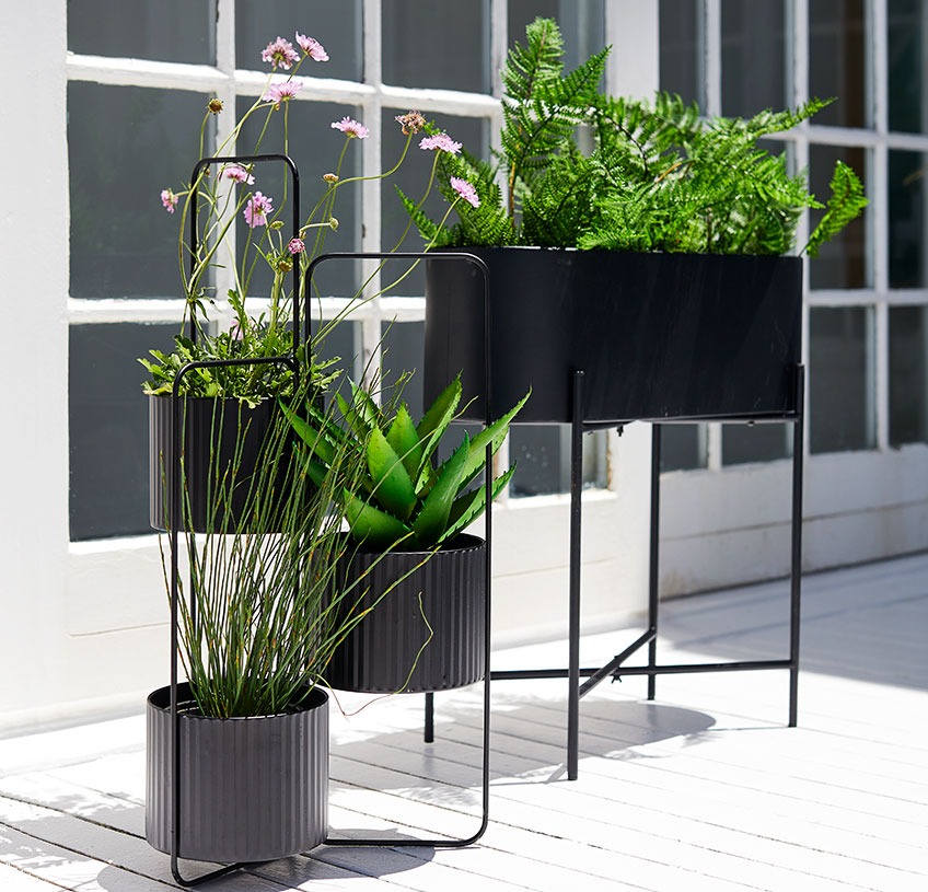 Plantekasse og potterholder på en solfylt terrasse