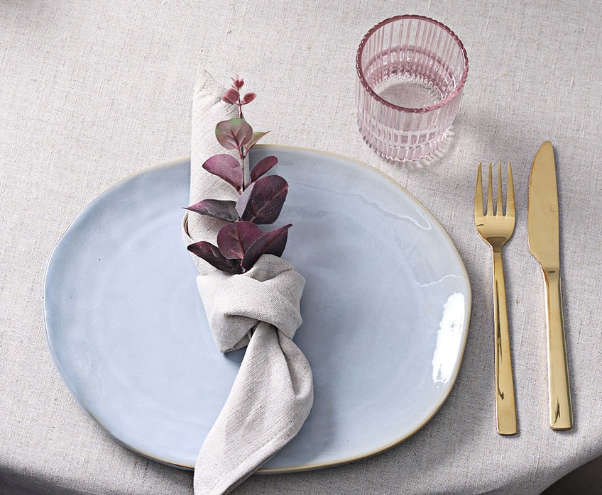 Decorative table setting with plate, cloth napkin, glass and knife and fork