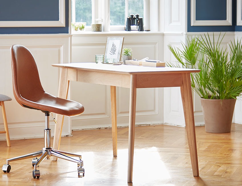 Skrivebord i eik og en kontorstol i lær i et stilig rom