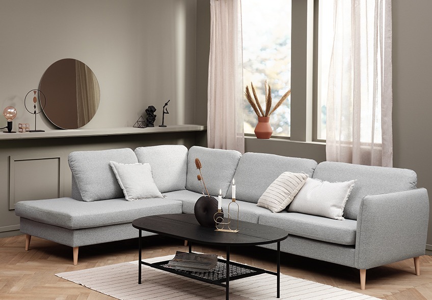 Living room with a large light grey sofa with open-end and a black coffee table 