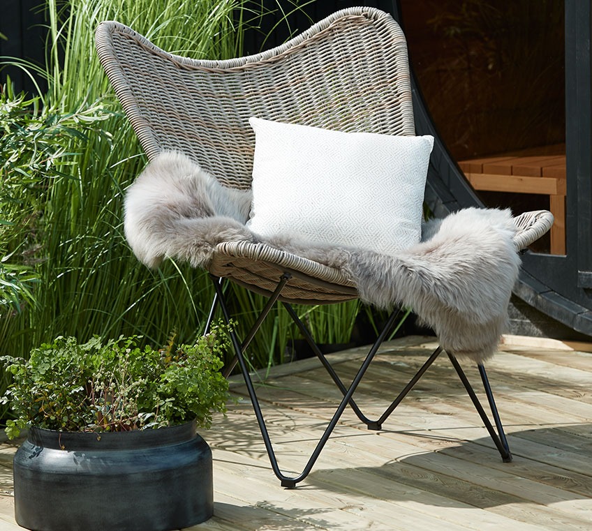Rattan lounge chair with a hide and a cushion 