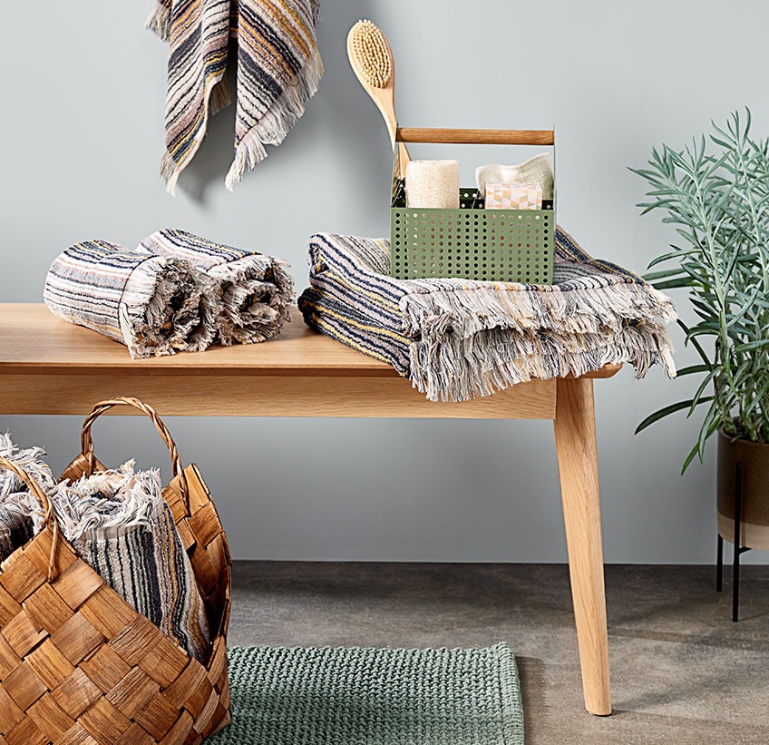 SEGERSTA towels in different sizes, VICKLEBY storage box with VALJE bath brush on KALBY bench Cotton towels and other bathroom accessories on a bench