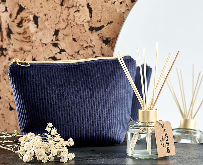 KRIKA toiletry bag is available in dark blue and sand. LINDOM scented oil is available in vanilla and lemon grass Toiletry bag in dark blue and scented oil in front of a bathroom mirror
