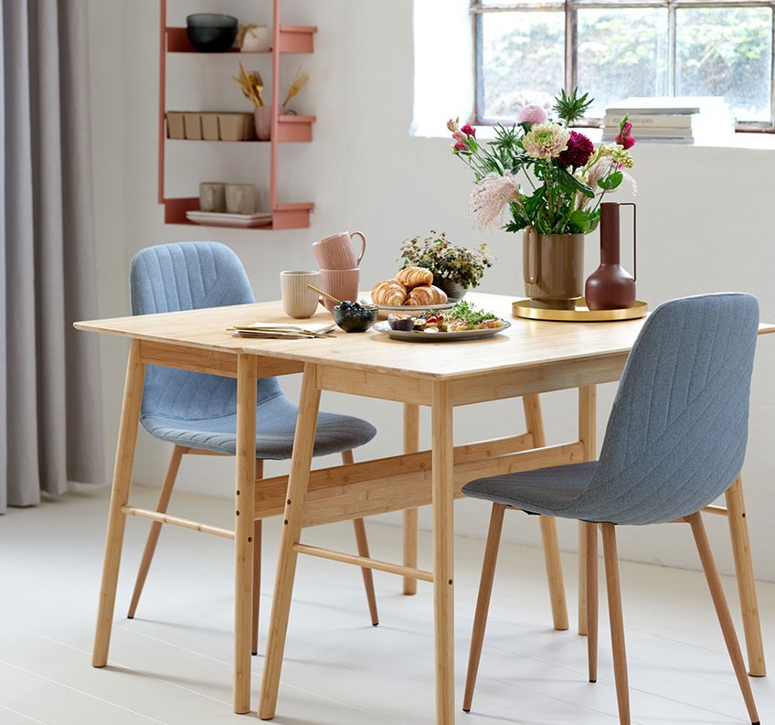 Bambusbord kombinert med et spisebord og grå spisestoler