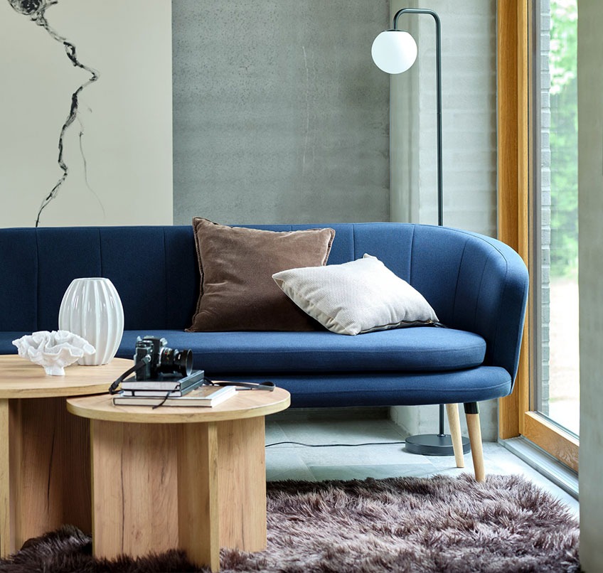 GISTRUP sofa, KALVEHAVE sofabord, STORMHATT teppe og ADRIAN gulvlampe Blå sofa, runde stuebord, brunt teppe og gulvlampe