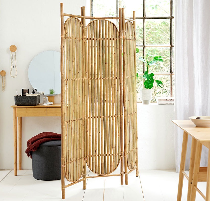 Bambus omkledningsskjerm fungerer som den romdeler mellom en spisestue og en soverom