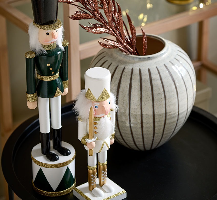 To julefigurer og en vase på et  svart sidebord