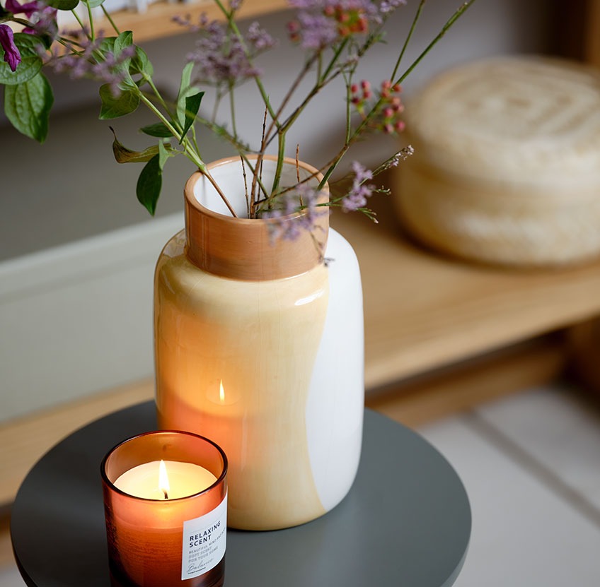 Vase og duftlys på et blomsterbord