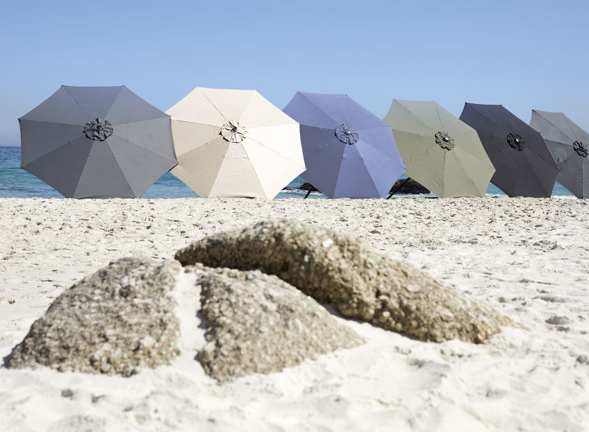 Parasoller i forskjellige farger på en strand 