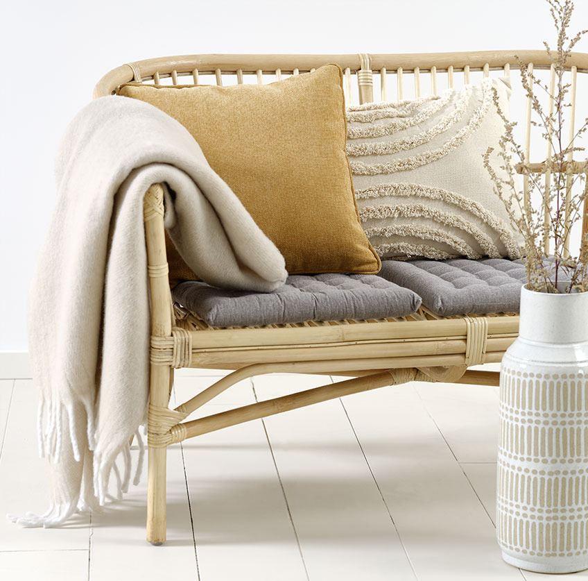 LISELEJE sofa med beige GRAVMYRT pute, gul HORNFIOL pyntepute og TUSENFRYD pledd Rattan sofa med beige og gule puter og beige pledd