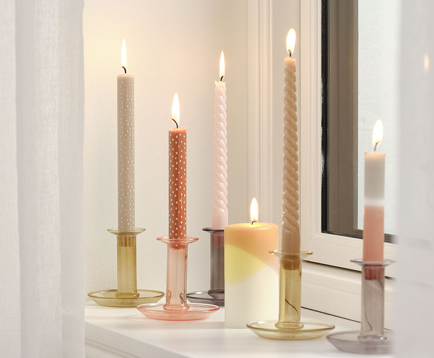 JULIAN stearinlys med prikker, VEGAR kubbelys, vridd BALDUR stearinlys og INGI tofarget lys i EDGAR glass lysestaker Stearinlys i lysestaker i vinduskarmen