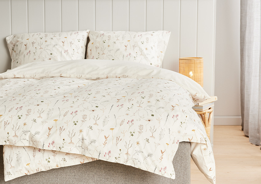 SUSSI er et sengesett med blomstermønster på offwhite bakgrunn
