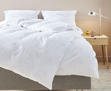 Lyst sengesett med teksturert mønster