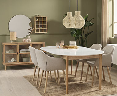 Spisebord med fire spisestoler i en grønn stue