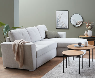 Sofabord i sett med fire ben foran en lys sofa i stue